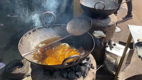 High-angle-shot-over-bengali-Lluchi-frying-in-progress-in-a-roadside-stall-in-India-on-a-bright-sunny-day