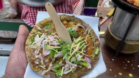 Close-up-shot-over-famous-bengali-dish-Ghugni-made-of-chickpeas-and-potato-with-toppings-of-coriander-and-onion-along-a-roadside-stall-at-daytime