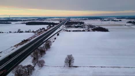 Canada-highway-401-gas-station-covered-in-snow-with-farm-and-field-in-background-60fps-aerial-drone-shot-dolly,-winter