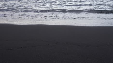Tenerife-black-volcanic-sand-beach-with-gentle-waves-lapping-on-the-shore
