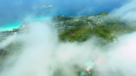 Mahe-Seychelles-,-morn-Seychellois-national-park,-drone-over-national-park-above-clouds,-the-tea-factory-can-be-seen-below