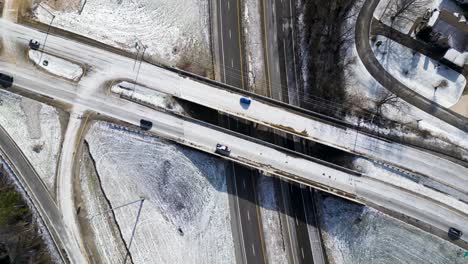 bridge-on-the-highway-in-winter-with-snow,-Ariel-drone-shot,-freeway-bridge-covered-with-with-snow