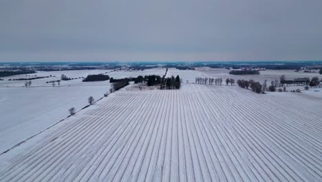 Ploughed-field-Snow-covered-farm-in-London,-Canada,-farm-landscape-with-aerial-drone-view-60fps