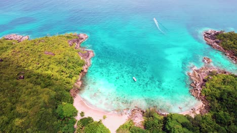 Mahe-Seychelles-boat-leaving-the-major-beach,-a-beach-in-the-nation-and-marine-park