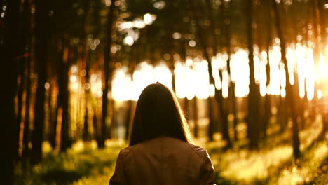 Girl-walking-in-the-forest-with-sunset-in-the-behind