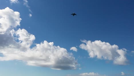 Transport-plane-approaching-airport-landing-against-blue-sky-clouds,-panning