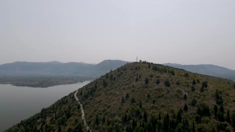 Aerial-clip-going-over-the-top-of-a-mountain-on-the-lake-of-Kastoria,-in-northern-Greece