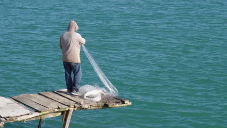 Fisherman-retrieving-his-net-on-a-pier