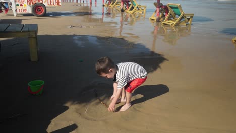 Ein-Kleiner-Junge,-Der-Am-Strand-Spielt