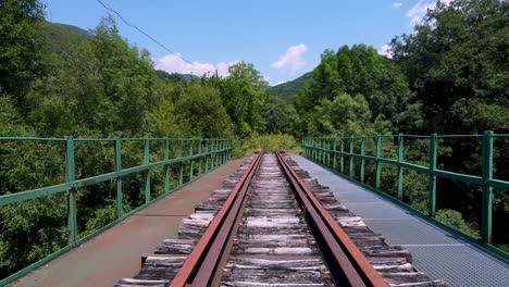 An-old-and-abandoned-railroad-track-over-a-bridge-in-the-countryside---forward-motion-or-train-point-of-view