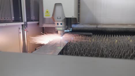 Industrial-laser-cuts-a-metal-sheet-and-sparks-fly