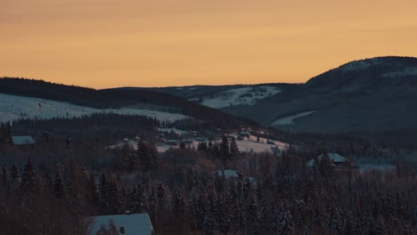 Picturesque-Orange-Sunset-Skies-Over-Winter-Hillside-Landscape-In-Norway