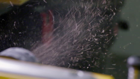 Sawdust-spitting-out-of-a-planer-in-slow-motion