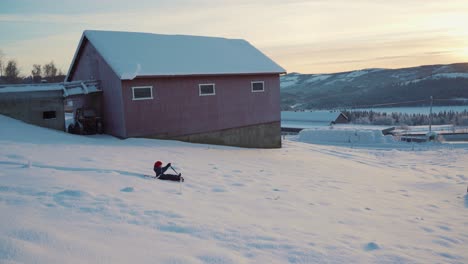 A-young-boy-facing-a-bit-of-trouble-on-his-sledding-trip-in-the-frosty-and-snowy-landscape-of-Norway-during-Christmas-time