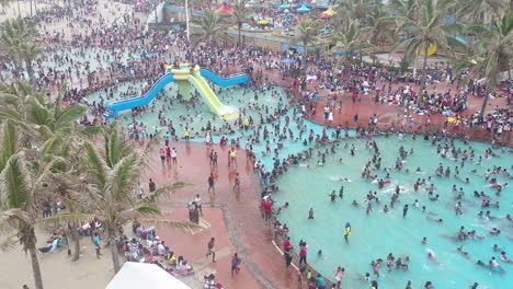 Drone-shot-of-Large-crowds-on-Durban-beachfront-in-the-public-pools