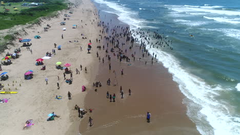 Drohne-Schoss-Auf-Menschen,-Die-Im-Sommer-In-Durban,-Südafrika,-Mit-Pavillons-Und-Sonnenschirmen-Den-Strand-Genießen