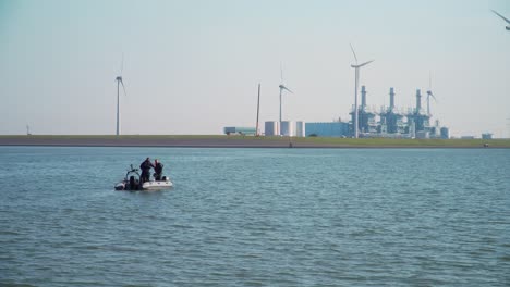 Navy-Practising-in-Open-Sea-with-Industry-and-Windmills-Background,-Eemshaven