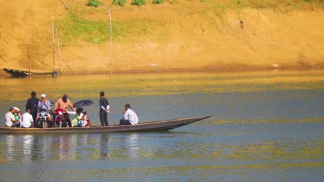 Group-of-people-crossing-Surma-river-in-wooden-boat,-handheld-view