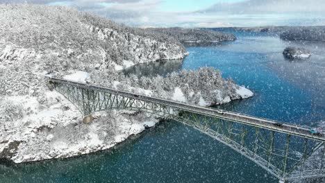Aerial-shot-of-Deception-Pass-Bridge-with-active-snowfall