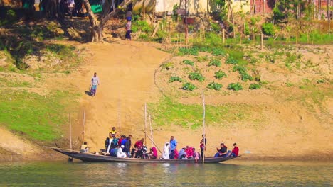 People-getting-into-wooden-boat-to-cross-Surma-river-at-a-rural-village,-handheld-view