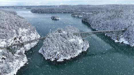 Drone-shot-of-Deception-Pass-connecting-Fidalgo-and-Whidbey-Island-with-snow-actively-falling