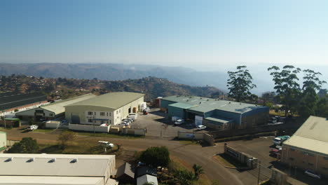 Drohne-Enthüllt-über-Industrielagern-Und-Fabriken-In-Südafrika-Mit-Dem-Tal-Der-Tausend-Hügel-Im-Hintergrund