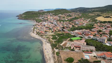Lu-Bagnu-Beach-and-coastal-town-near-Castelsardo,-Sardinia---Aerial-4k