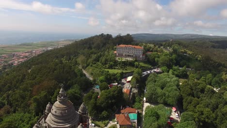 Aerial-Dolly-Forwards-Towards-Viana-Do-Castelo-Church-In-Portugal-On-Forested-Hilltop