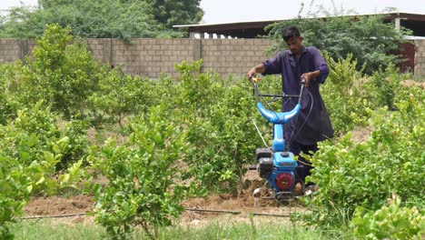 Agricultor-Pakistaní-Masculino-Manejando-Cultivador-De-Gasolina-Sobre-Suelo-En-Sindh,-Pakistán
