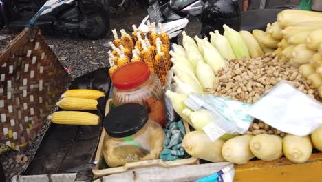 Gerösteter-Mais-Und-Erdnüsse-Straßenlebensmittelhändler-In-Indonesien-Bali-Grillt-Snackgericht-Am-Saba-Beach,-Braten,-Gianyar,-Traditionelle-Südostasiatische-Kulinarik