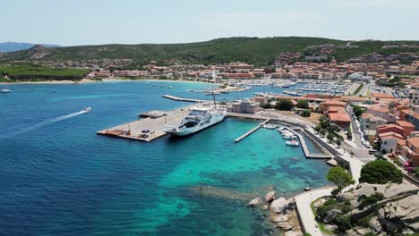 Ferry-Docks-at-Palau-Harbor-Town-in-Sardinia,-Italy---Aerial-4k-Pedestal-Up