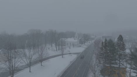 A-truck-drives-out-of-Monson-Town-during-snowfall-Aerial-Realtime