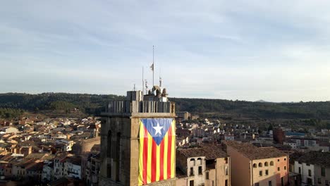 Toma-Aérea-Descendente-De-Una-Torre-Con-Una-Bandera-De-Catalunya