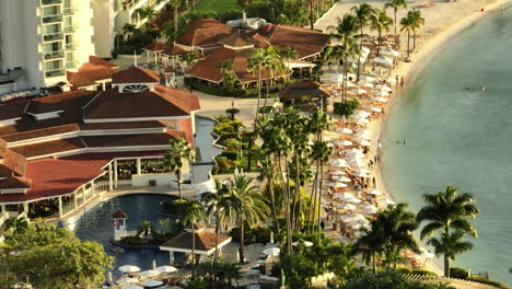 Vista-Aérea-De-Resort-De-Lujo-De-La-Playa-Y-La-Piscina,-Mientras-Las-Puestas-De-Sol-Sobre-El-Océano-Jamaicano