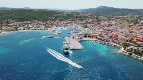 Ferry-from-La-Maddalena-Islands-docks-at-Palau-Harbor-Town-in-Sardinia,-Italy---Aerial-4k