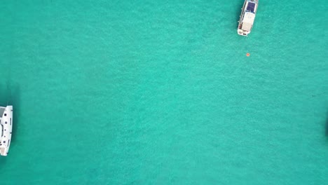 Boote,-Die-Auf-Dem-Türkisblauen-Meer-Bei-La-Pelosa,-Sardinien,-Italien-Schwimmen---Antenne-4k-Zoom-Out