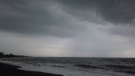 Black-Sand-Beach-with-Dark-Rainy-Cloudy-Sky-Storm-Approaching-Black-Heavens-in-Saba-Beach,-Gianyar,-Bali,-Indonesia