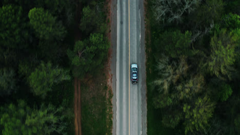 Aerial-Top-Down-View-of-Car-Driving-Down-Empty-Forest-Road-Surrounded-by-Trees-Cinematic-Drone-Travel-Adventure-Vacation-4K
