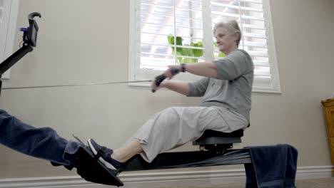 Senior-woman-on-a-rowing-machine-at-home---sliding-view