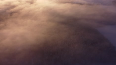 Volando-Sobre-Nubes-De-Niebla-Y-Bosques-Estacionales-Cubiertos-De-Escarcha-A-La-Luz-Del-Amanecer