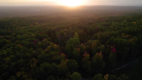 Aerial-of-a-sunrise-over-fall-foliage-trees-in-the-New-Hampshire-mountains-in-the-autumn