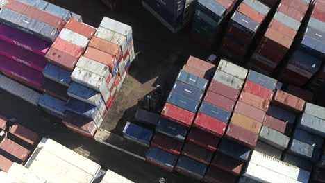 Luftdrohne-über-Einem-Containerstapler,-Der-Einen-Versandcontainer-In-Einem-Containerlager-Bewegt