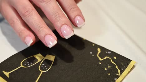 perfect-French-manicure-of-womans-finger-nails,-party-napkin-contrast