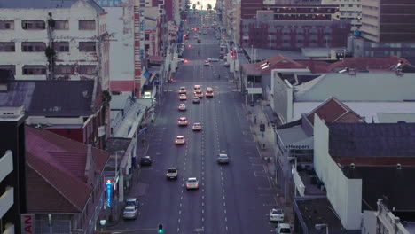 Early-morning-aerial-drone-shot-through-Durban-city-centre-in-South-Africa,-cars-and-taxis-driving-along-the-roads