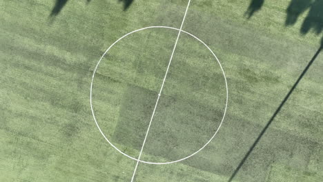 Aerial-footage-of-taking-off-from-a-soccer-field-while-spinning