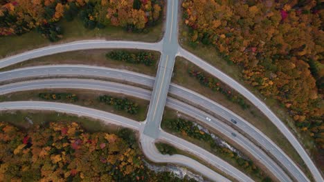 Top-down-aerial-of-a-highway-road-in-the-mountains-during-the-fall