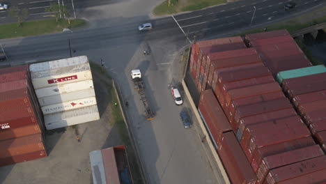 Aerial-Drone-tracking-an-empty-truck-leaving-a-shipping-container-yard,-South-Africa