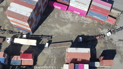 Aerial-drone-shot-of-Empty-trucks-lined-up-in-a-container-yard-waiting-to-be-loaded-with-shipping-containers