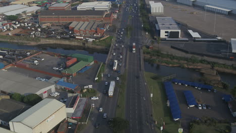 Pista-De-Drones-A-Lo-Largo-De-Una-Carretera-Muy-Transitada-En-Durban-A-Través-De-Un-área-Industrial-Siguiendo-Camiones-Y-Automóviles