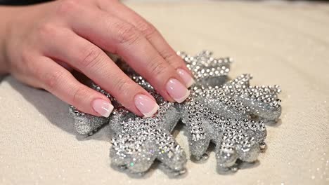 perfect-French-manicure-finger-nails-over-a-sparkling-snowflake-Christmas-ornament